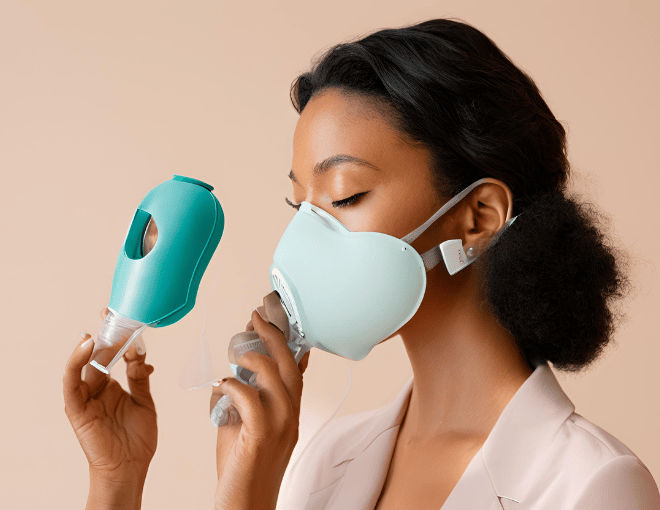 A beautiful woman with smooth skin using a portable respirator device